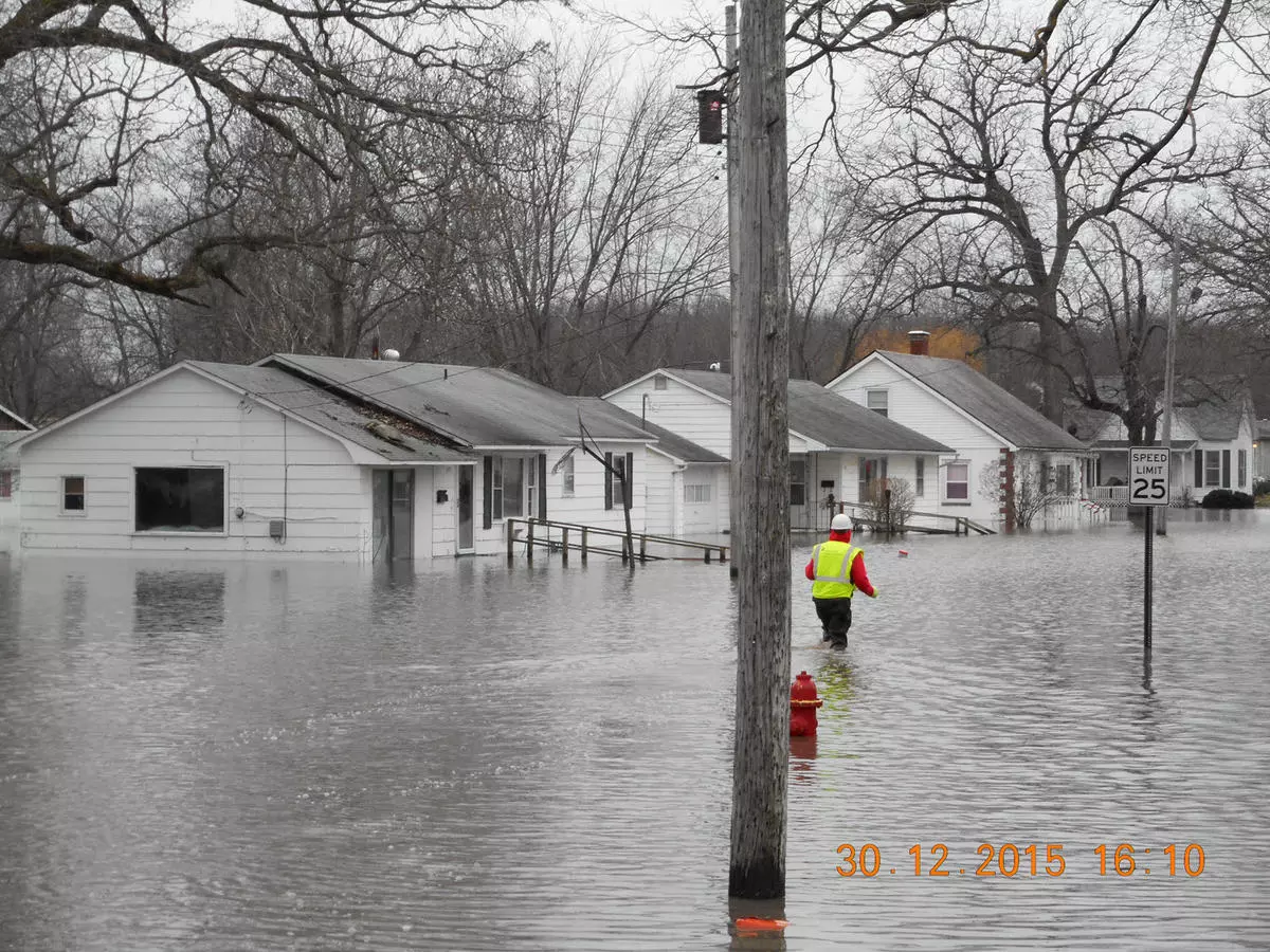 man walking through knee-high water
